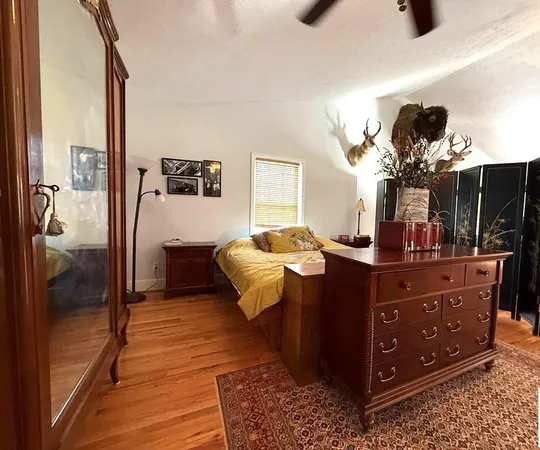 a bedroom with a bed and a mirror on dresser