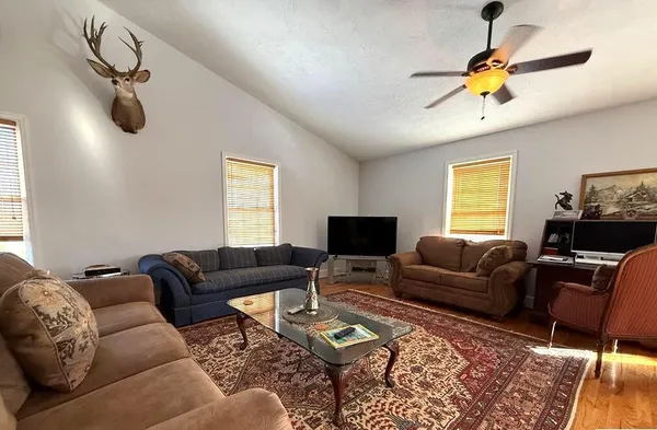 a living room with furniture a flat screen tv and a window