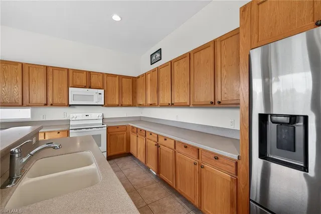 a kitchen with a refrigerator sink and cabinets