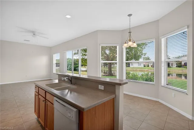 a kitchen with stainless steel appliances granite countertop a sink and a large window