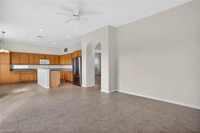 an open kitchen with a refrigerator and a microwave