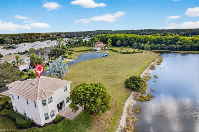 an aerial view of residential houses with outdoor space and lake view