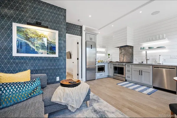 a kitchen with stainless steel appliances kitchen island granite countertop a refrigerator and a sink