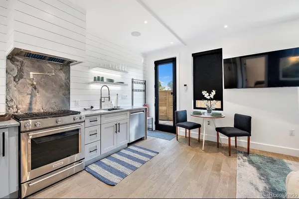 a kitchen with a stove and a wooden floor