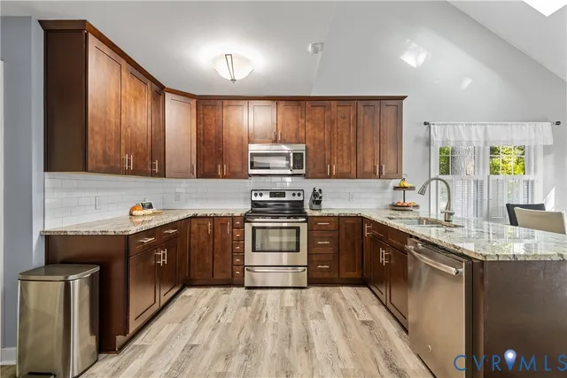 a kitchen with stainless steel appliances granite countertop a sink stove and refrigerator