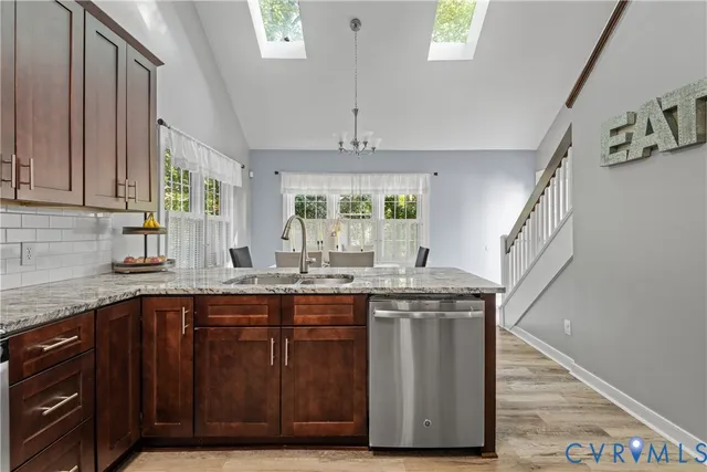 a kitchen with stainless steel appliances granite countertop a refrigerator and a sink