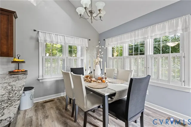 a kitchen with a dining table chairs and refrigerator