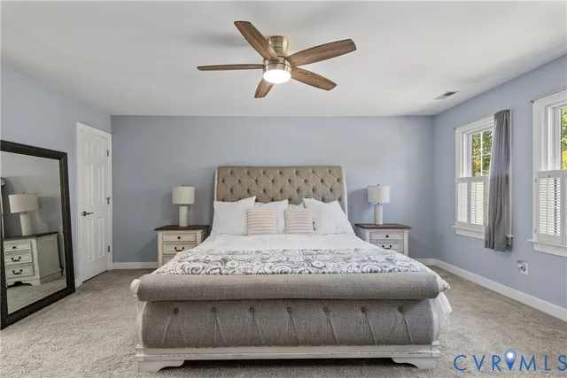 a spacious bedroom with a bed and a chandelier