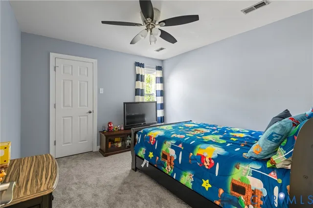 a bedroom with a bed and a chandelier fan