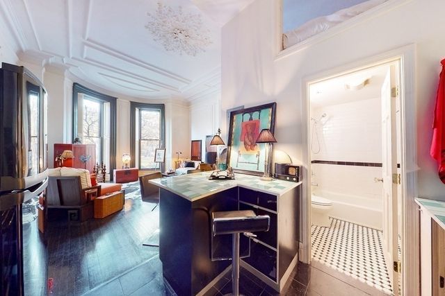 a kitchen with kitchen island wooden cabinets and refrigerator