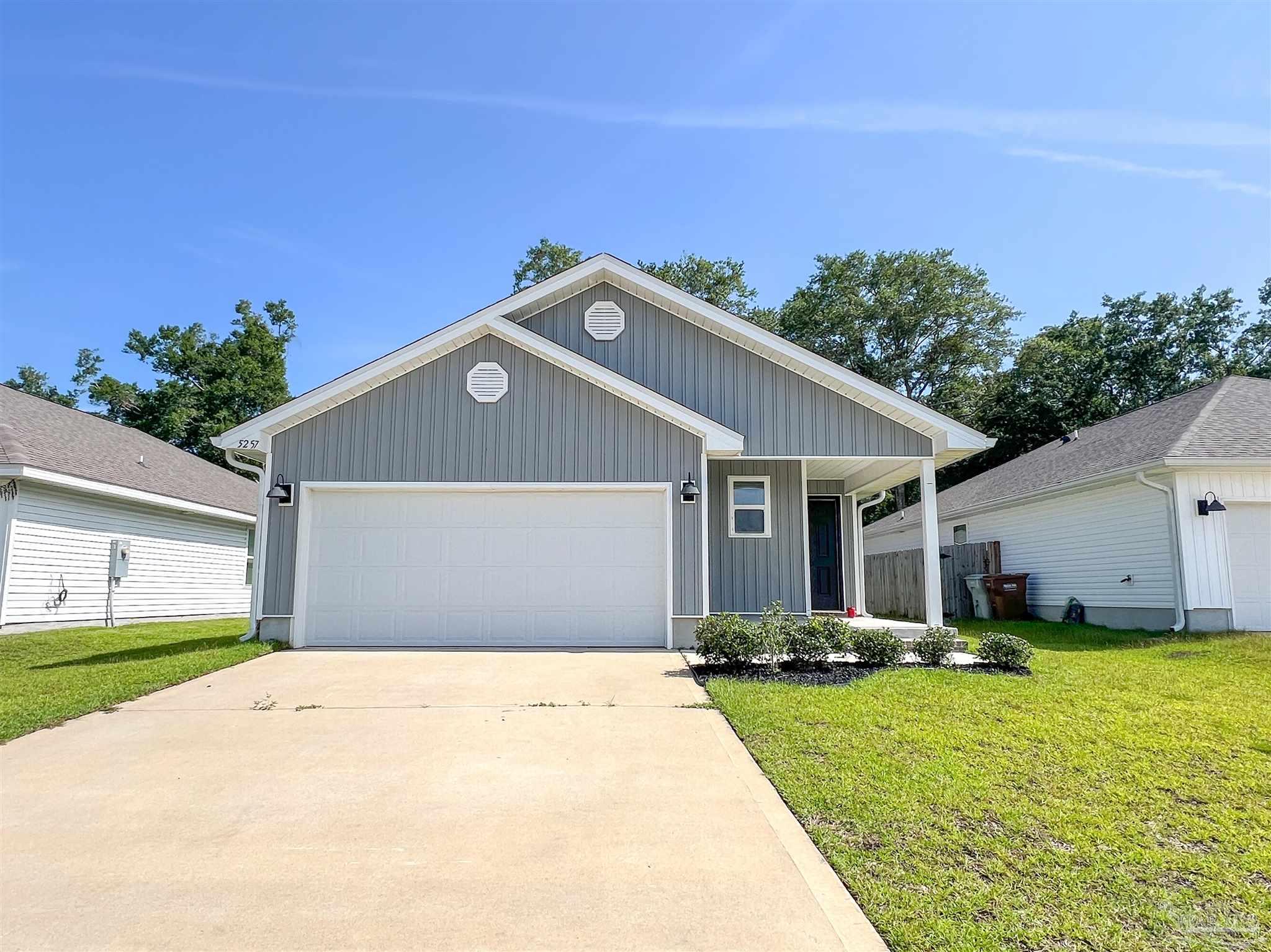 5257 Peach Drive Pace, FL 32571 - Photo 1 of 28 a front view of a house with a yard and garage
