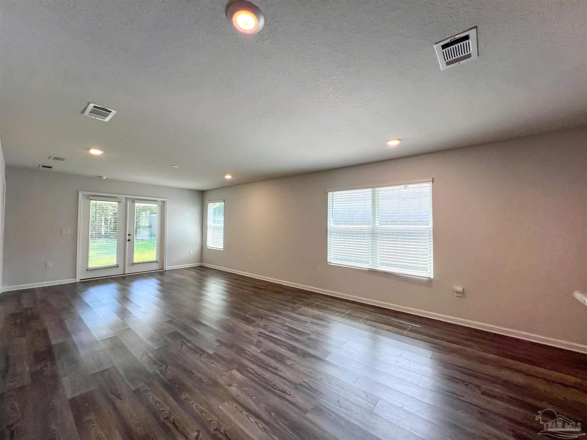5257 Peach Drive Pace, FL 32571 - Photo 4 of 28 an empty room with wooden floor and windows