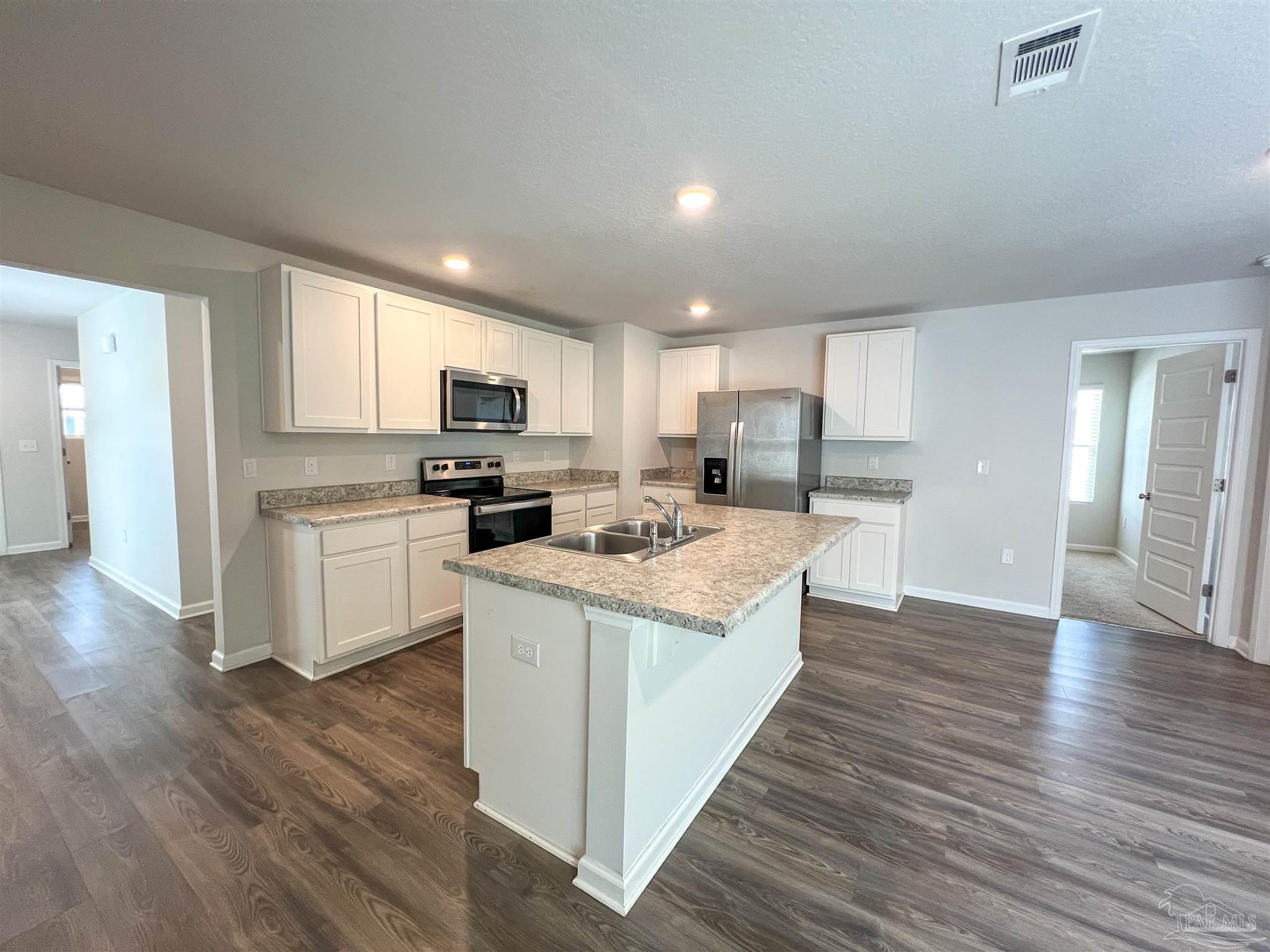 5257 Peach Drive Pace, FL 32571 - Photo 6 of 28 a kitchen with granite countertop a stove top oven and cabinets