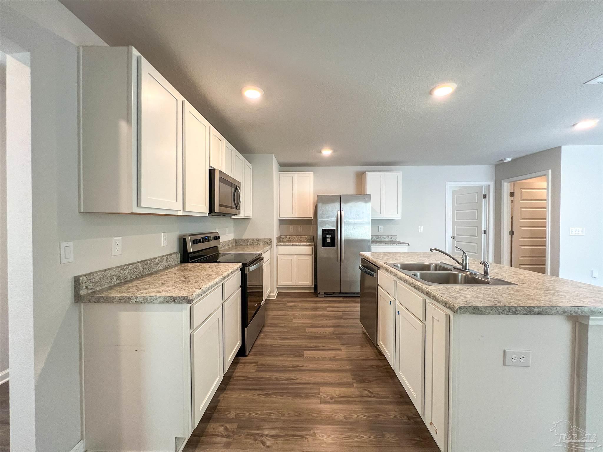 5257 Peach Drive Pace, FL 32571 - Photo 7 of 28 a kitchen with a stove top oven sink and cabinets
