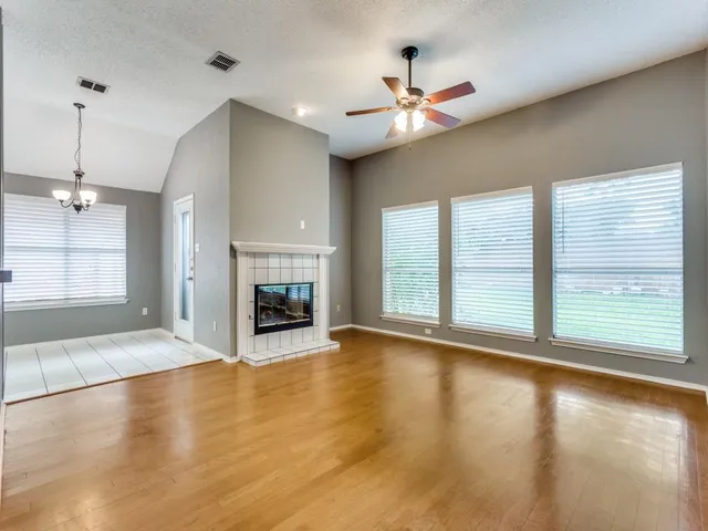 a view of an empty room with window and fire place