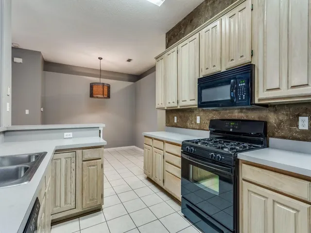 a kitchen with granite countertop a stove sink and cabinets