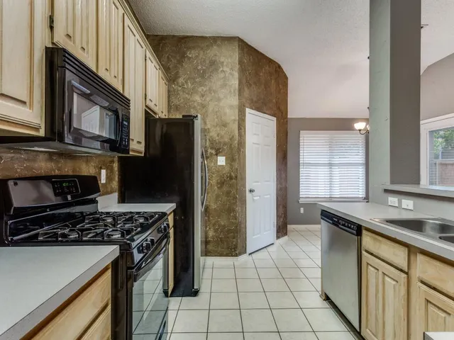 a kitchen with a sink a stove and a refrigerator