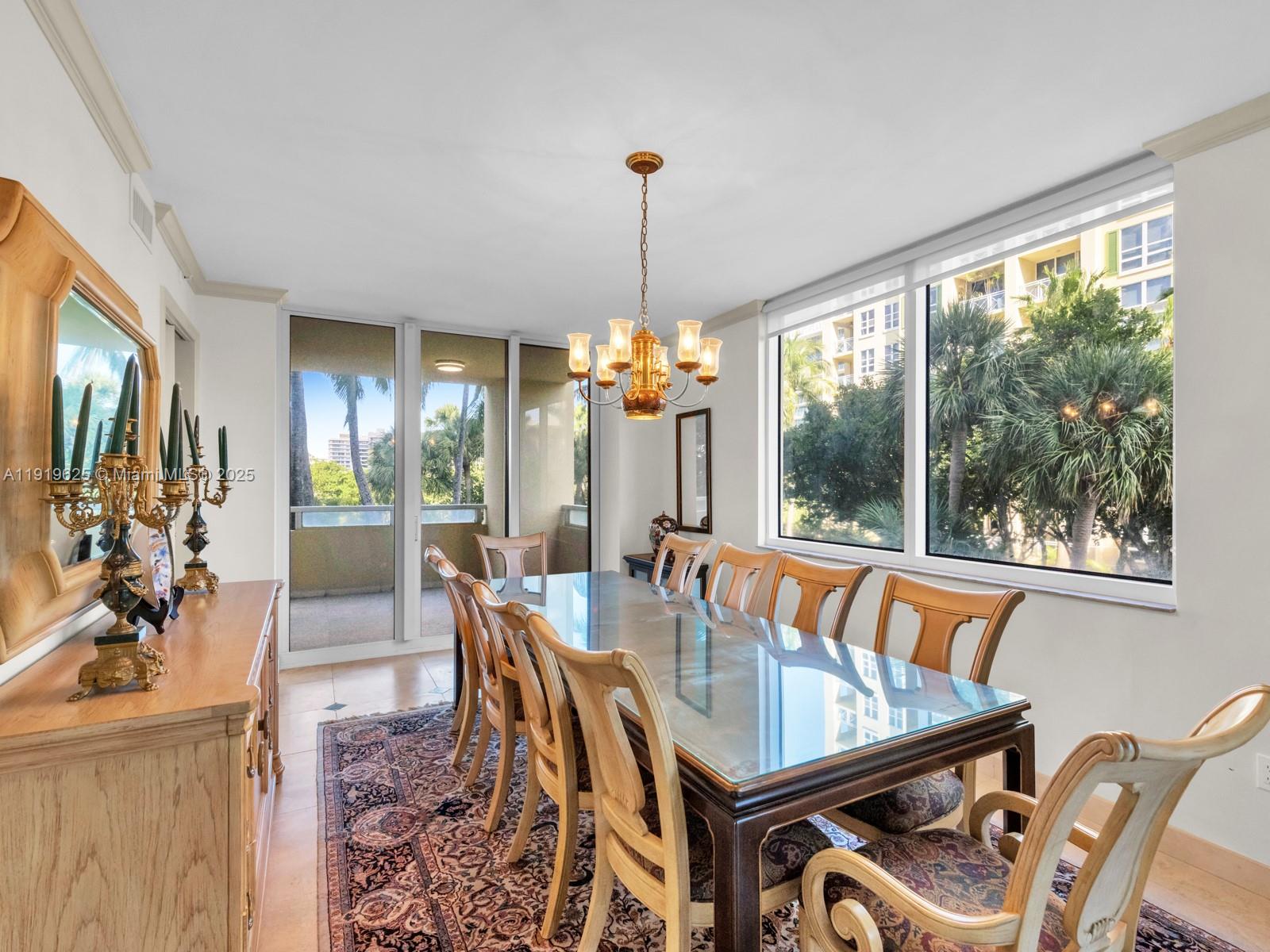 445 Grand Bay Drive, Unit 303 Key Biscayne, FL 33149 - Photo 21 of 52 a dining room with furniture a chandelier and window