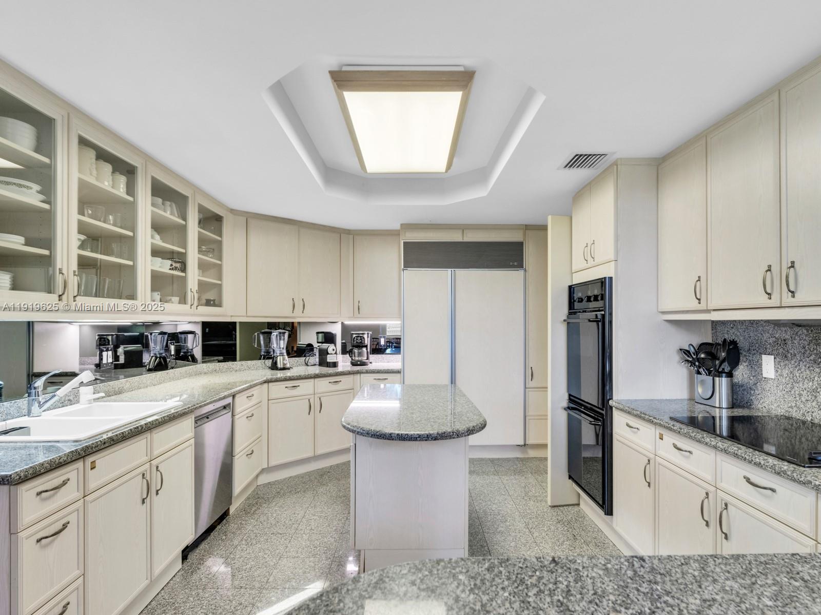 445 Grand Bay Drive, Unit 303 Key Biscayne, FL 33149 - Photo 24 of 52 a kitchen with granite countertop a sink a stove cabinets and stainless steel appliances