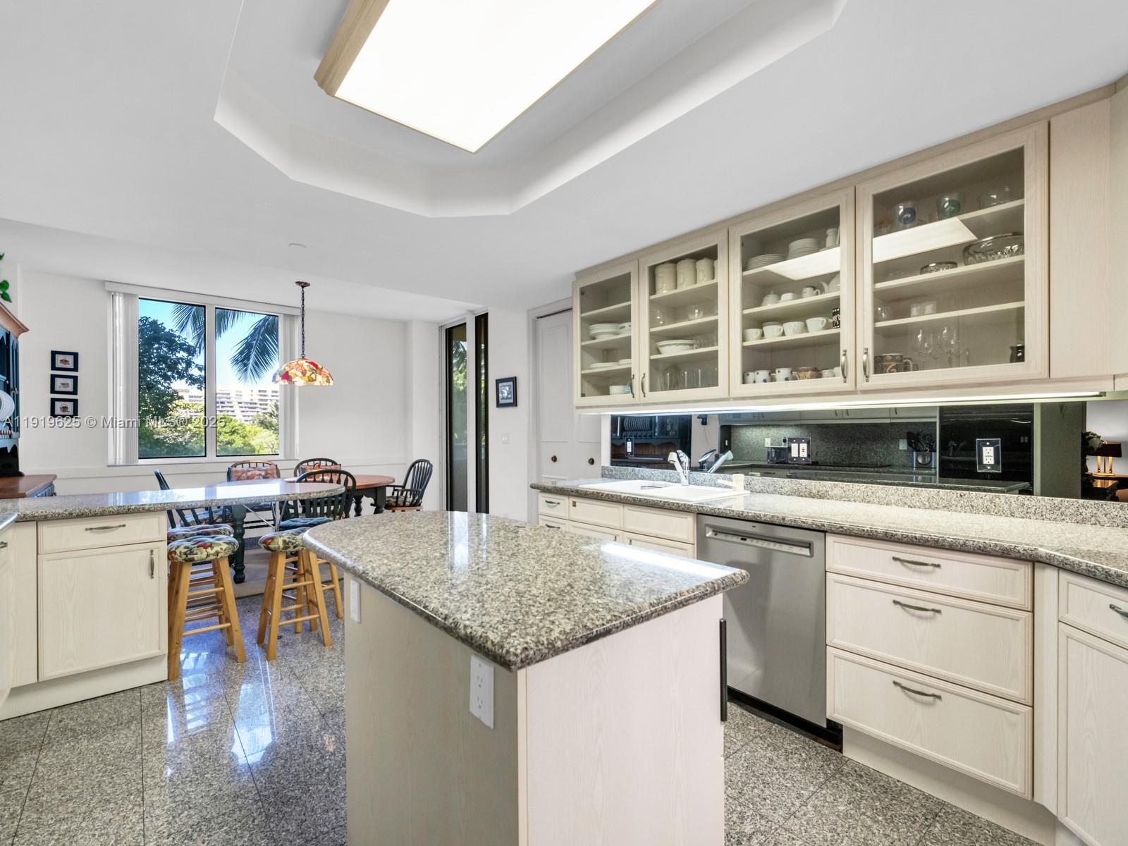 445 Grand Bay Drive, Unit 303 Key Biscayne, FL 33149 - Photo 25 of 52 a kitchen with a stove top oven a sink a counter space and a window