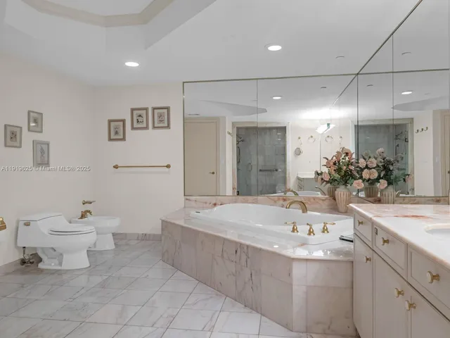 a bathroom with a tub a sink shower and mirror