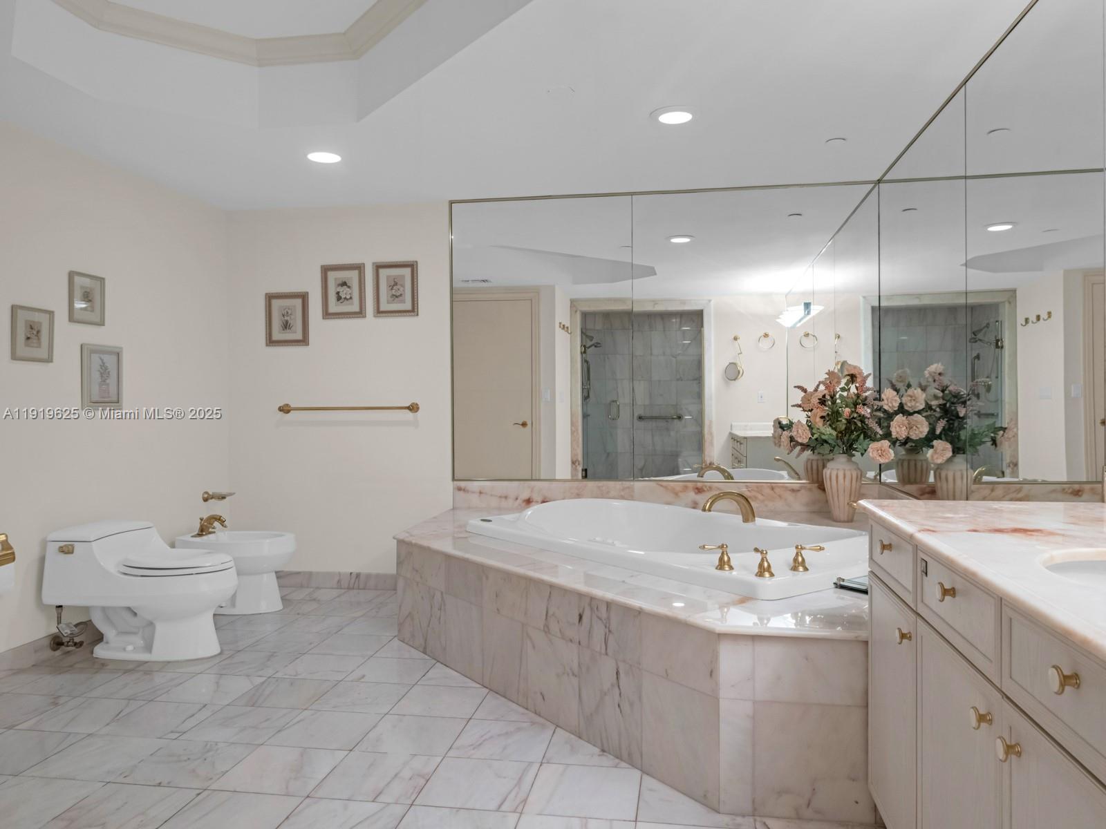 445 Grand Bay Drive, Unit 303 Key Biscayne, FL 33149 - Photo 35 of 52 a bathroom with a sink a toilet and a large mirror