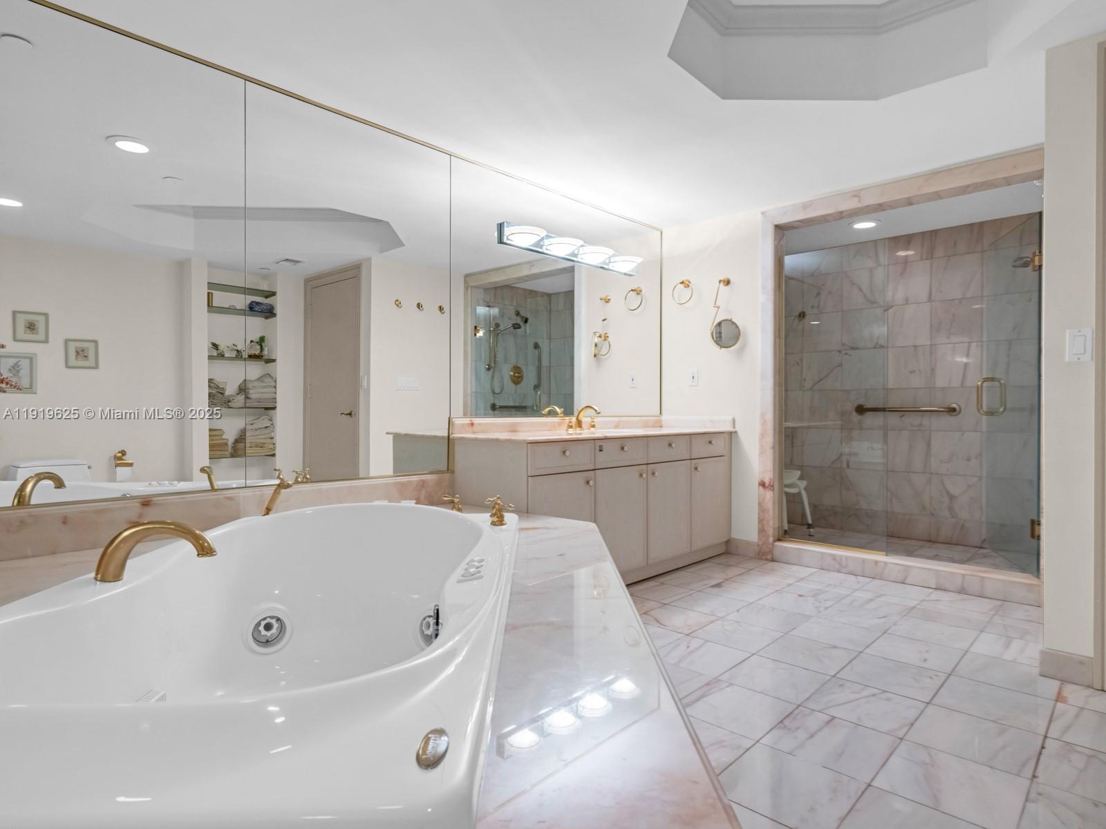 445 Grand Bay Drive, Unit 303 Key Biscayne, FL 33149 - Photo 36 of 52 a bathroom with a tub a sink shower and mirror