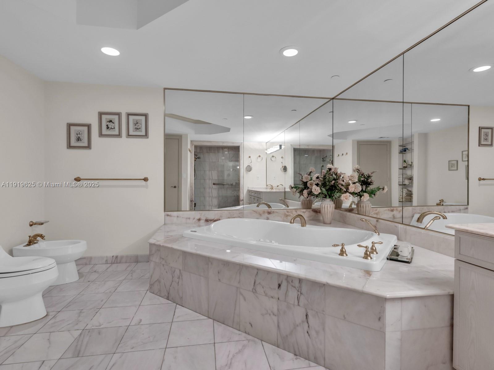 445 Grand Bay Drive, Unit 303 Key Biscayne, FL 33149 - Photo 37 of 52 a bathroom with a sink a toilet and a mirror