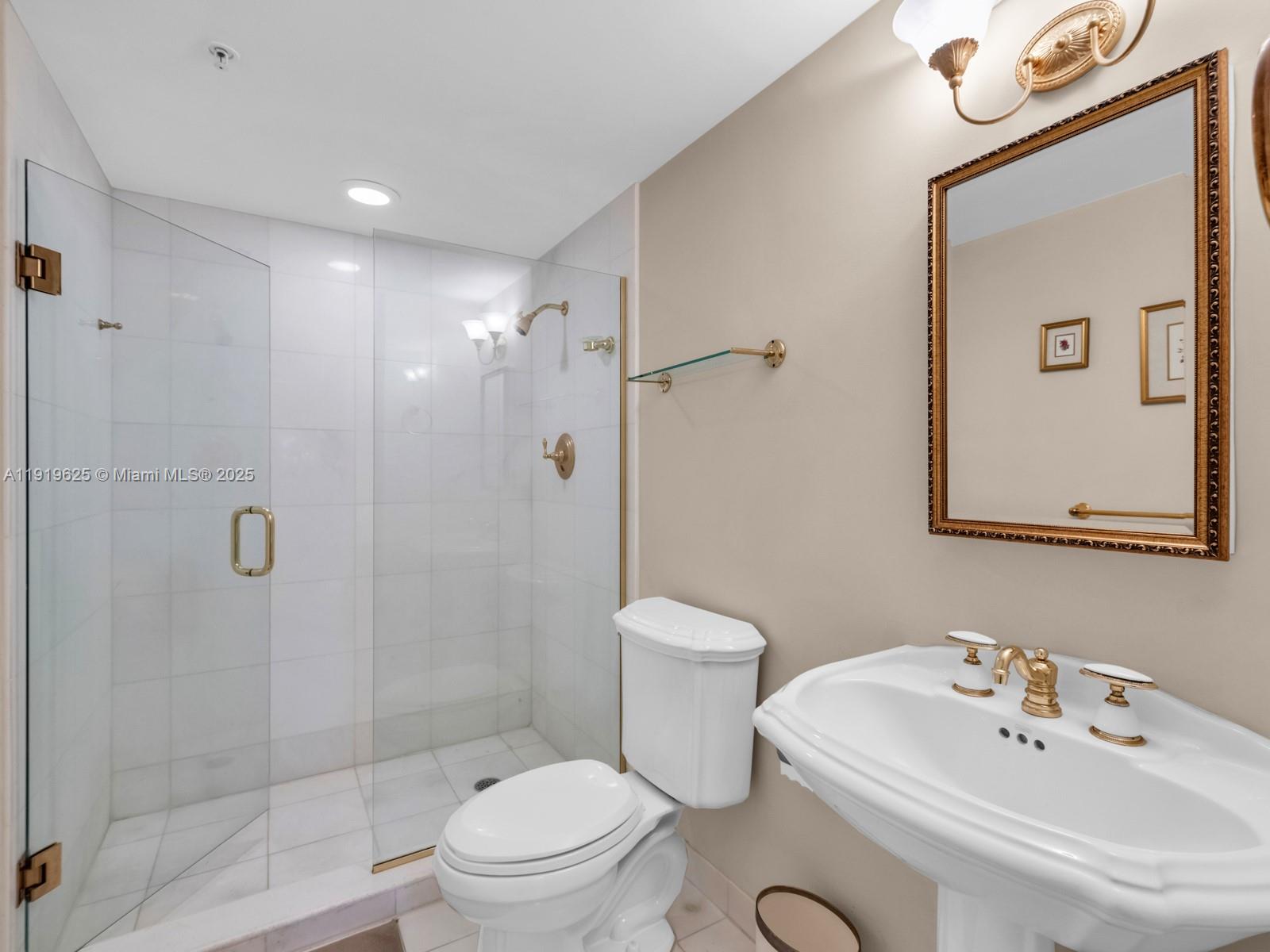 445 Grand Bay Drive, Unit 303 Key Biscayne, FL 33149 - Photo 38 of 52 a bathroom with a sink a toilet and shower