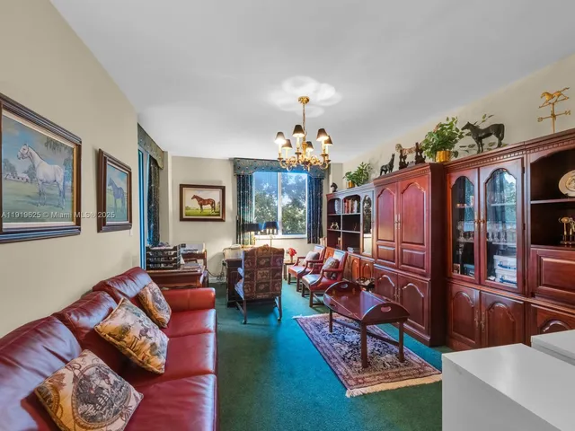 a living room with furniture a chandelier and a window