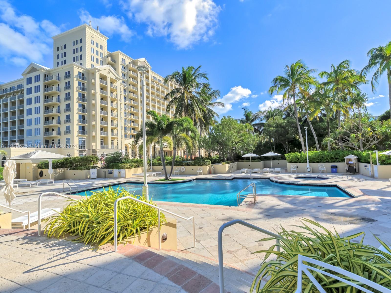 445 Grand Bay Drive, Unit 303 Key Biscayne, FL 33149 - Photo 49 of 52 a view of a swimming pool with a lounge chairs