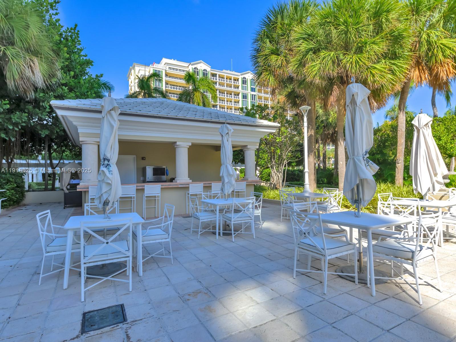 445 Grand Bay Drive, Unit 303 Key Biscayne, FL 33149 - Photo 52 of 52 a view of a patio with table and chairs and potted plants