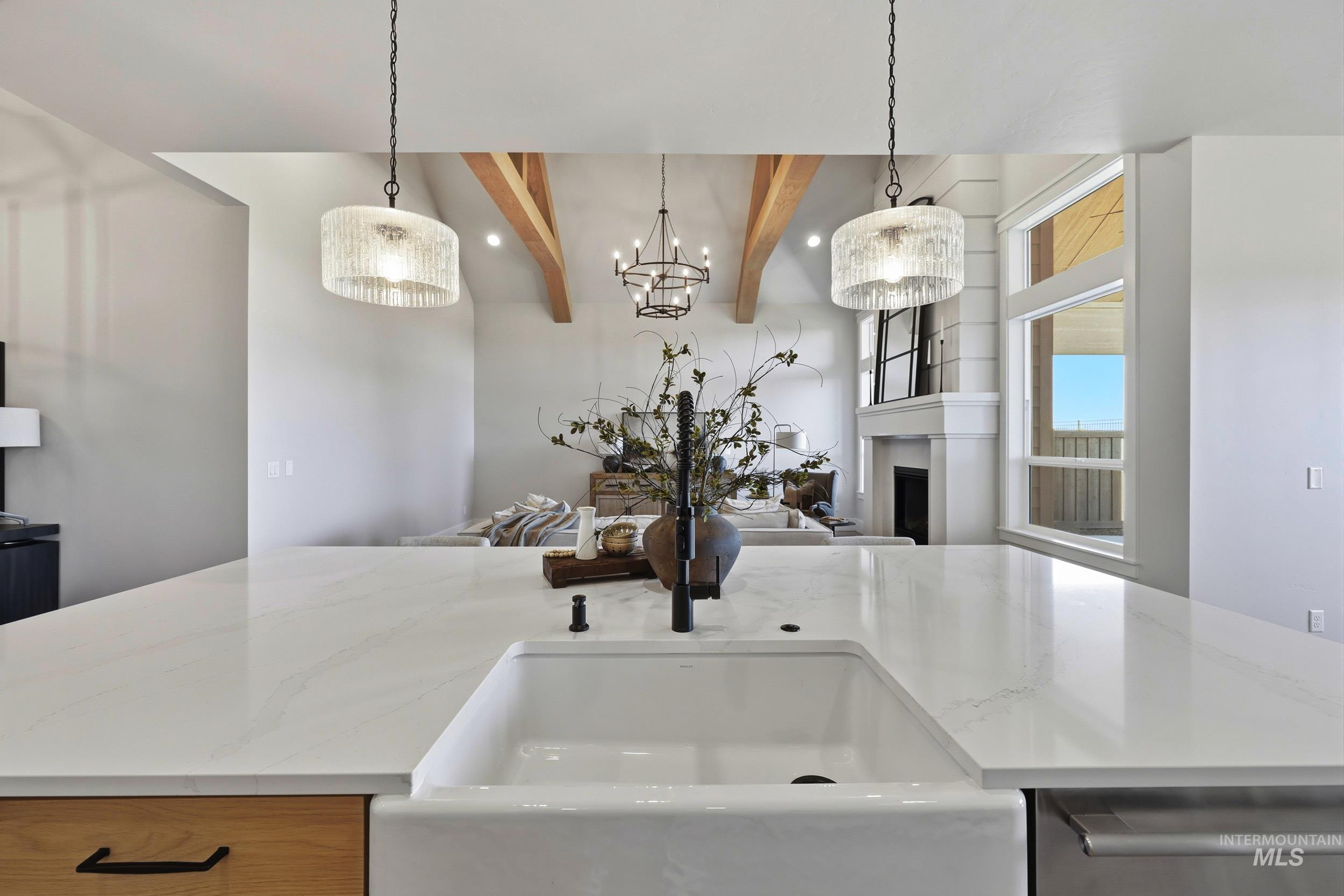 6771 South Messner Way Meridian, ID 83642 - Photo 20 of 45 Kitchen with beamed ceiling, a fireplace, light stone countertops, decorative light fixtures, and dishwasher