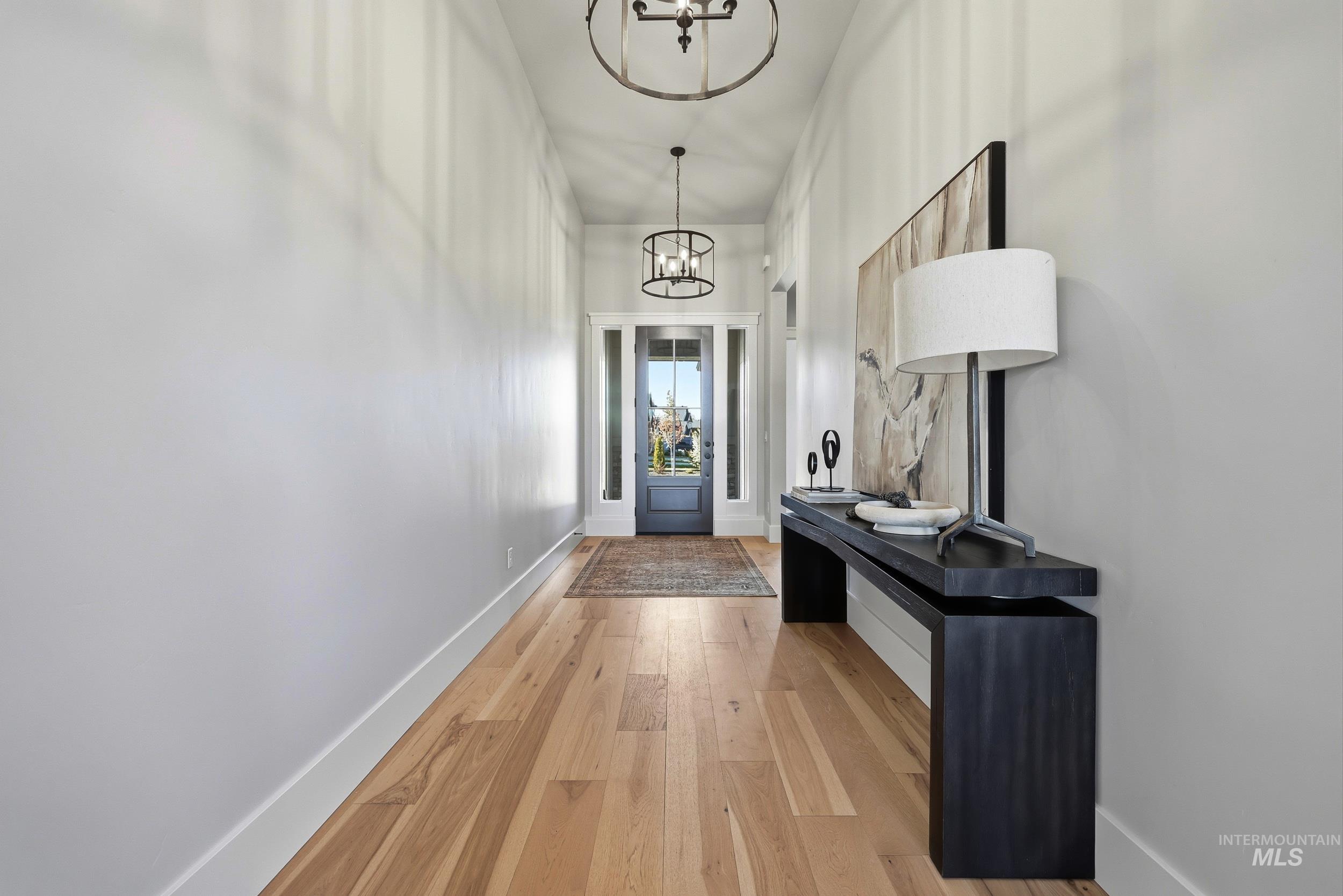6771 South Messner Way Meridian, ID 83642 - Photo 34 of 45 Doorway to outside featuring hardwood / wood-style flooring and a chandelier