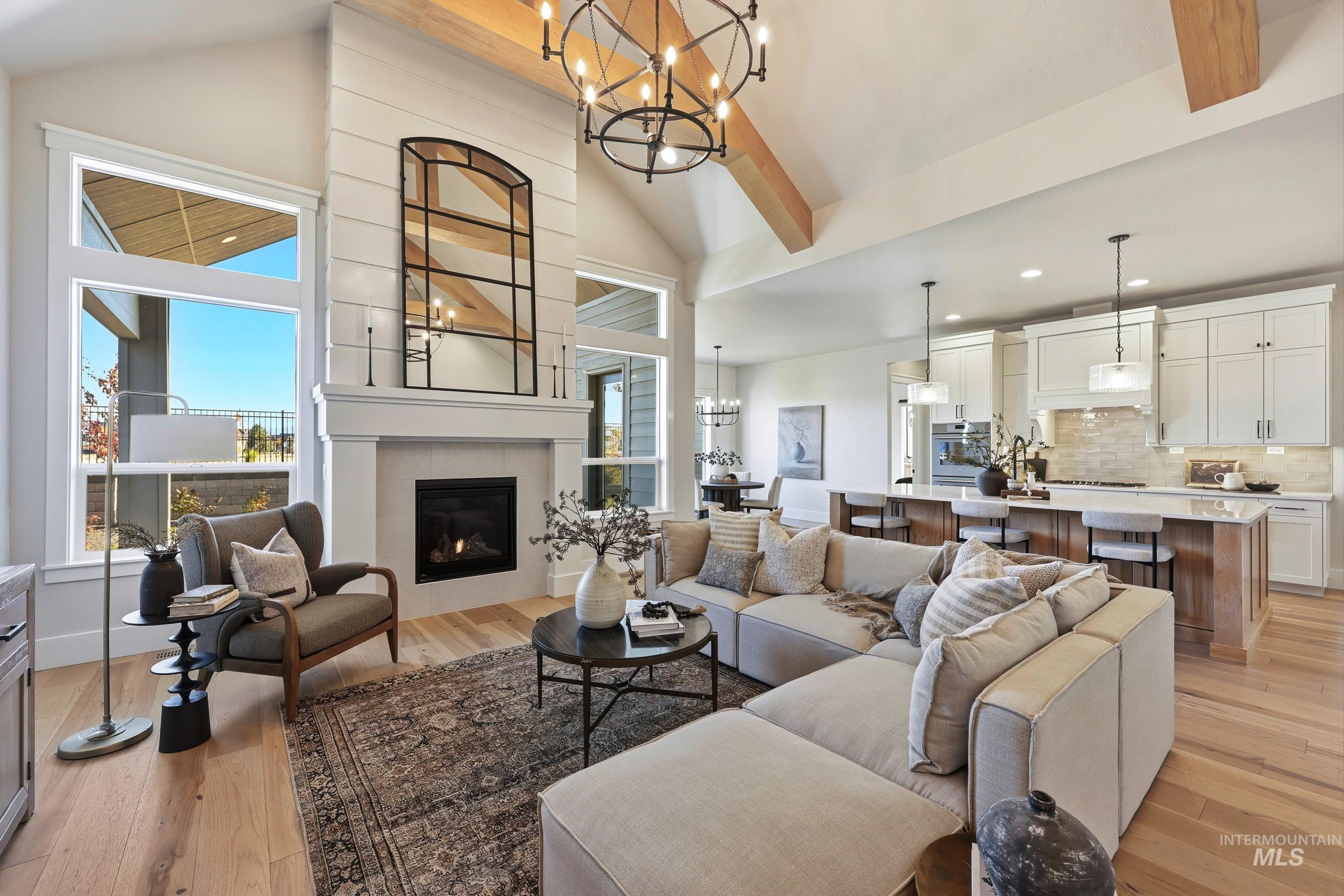 6771 South Messner Way Meridian, ID 83642 - Photo 8 of 45 Living area featuring light wood finished floors, a chandelier, plenty of natural light, and high vaulted ceiling