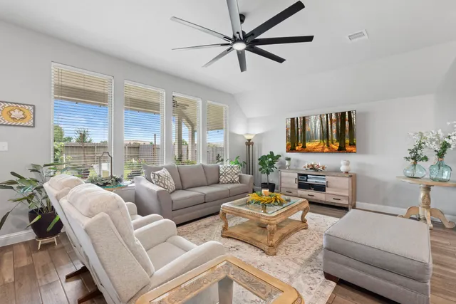 a living room with furniture a large window and a flat screen tv