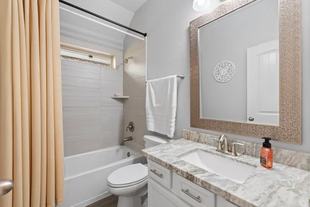 a bathroom with a granite countertop sink toilet and shower