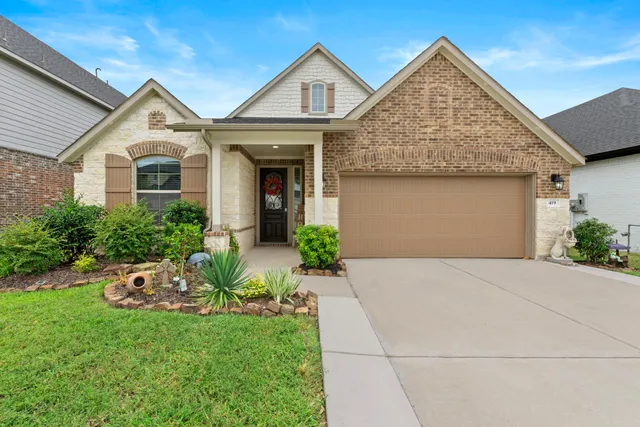 a front view of a house with a garden and plants