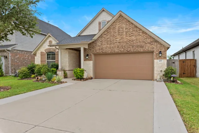 a front view of a house with a garden and plants