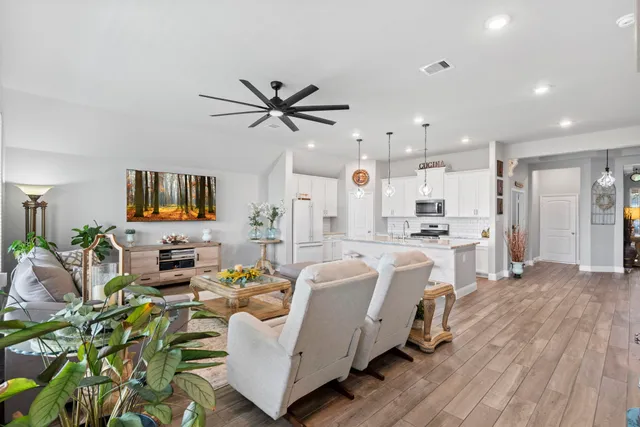 a very nice looking living room with a large window a rug and a couch