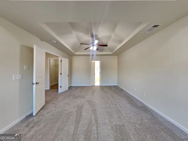en empty room with windows and ceiling fan