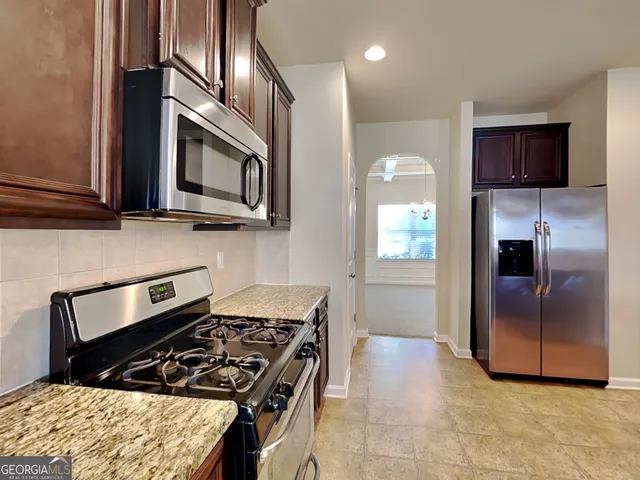 a kitchen with stainless steel appliances granite countertop a stove a microwave and a refrigerator