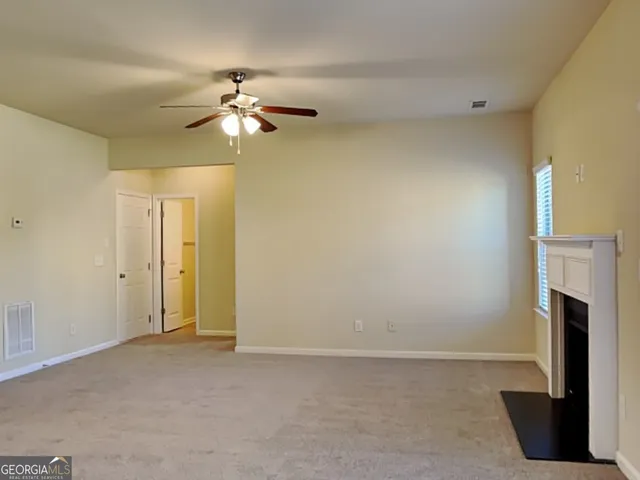 a view of a livingroom with a ceiling fan and a bathroom