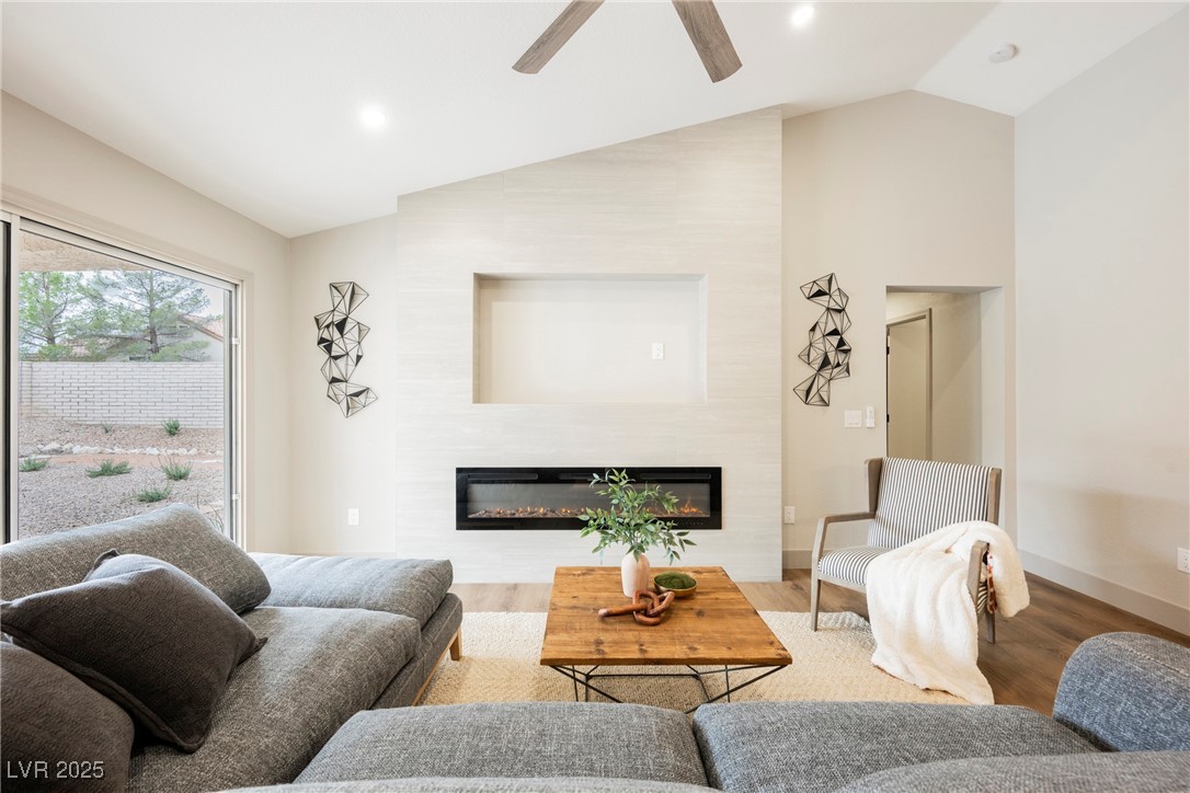 9337 Quail Ridge Drive Las Vegas, NV 89134 - Photo 13 of 28 Living room featuring wood finished floors, a glass covered fireplace, lofted ceiling, ceiling fan, and recessed lighting