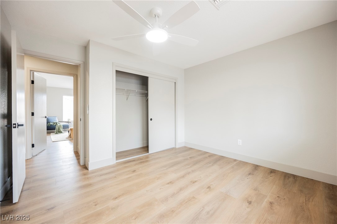9337 Quail Ridge Drive Las Vegas, NV 89134 - Photo 25 of 28 Unfurnished bedroom with light wood-type flooring, a closet, and a ceiling fan