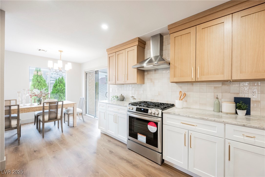 9337 Quail Ridge Drive Las Vegas, NV 89134 - Photo 3 of 28 Kitchen with stainless steel gas range oven, wall chimney range hood, tasteful backsplash, light stone countertops, and recessed lighting