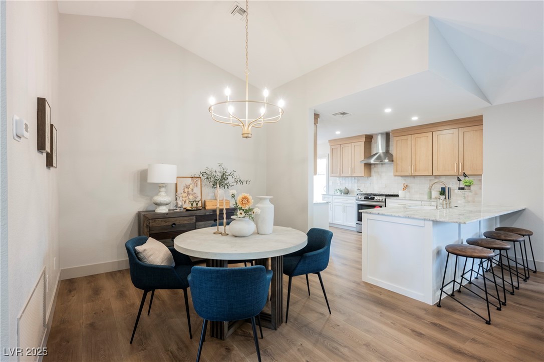 9337 Quail Ridge Drive Las Vegas, NV 89134 - Photo 4 of 28 Dining space featuring light wood-style floors, a chandelier, lofted ceiling, and recessed lighting