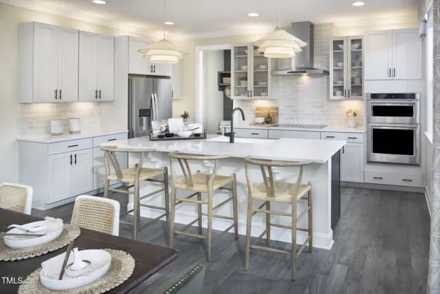 a kitchen with stainless steel appliances granite countertop a stove a sink a dining table and chairs