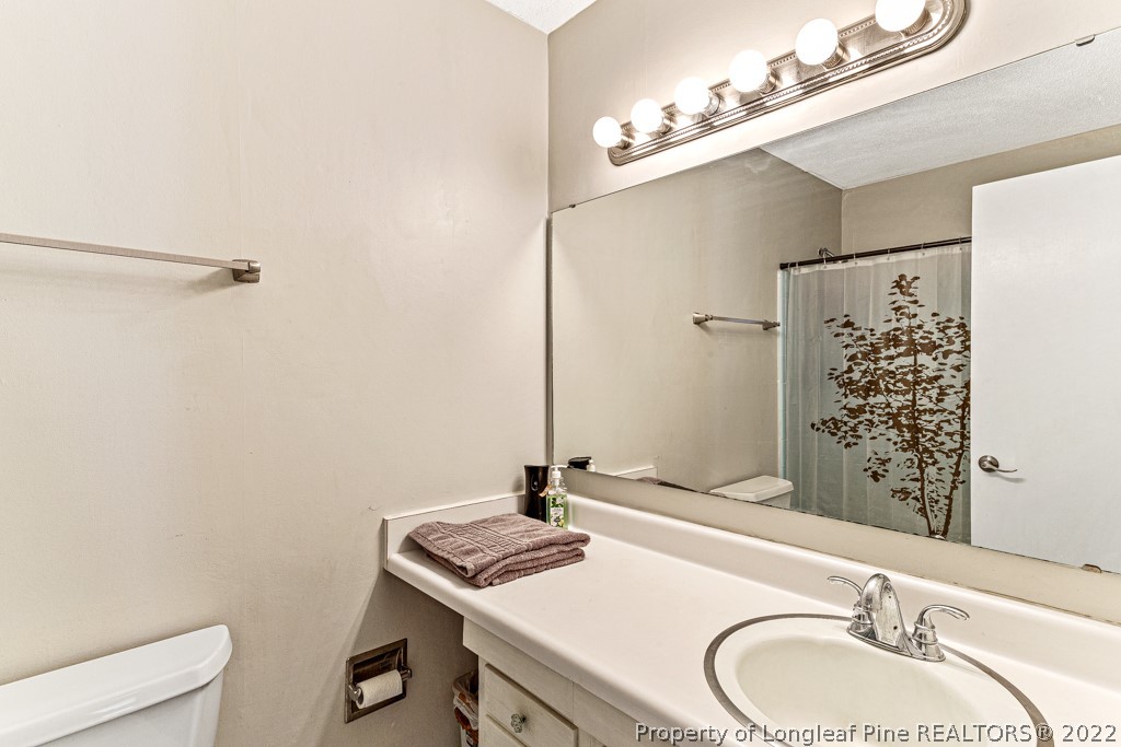 1435 Marlborough Road Fayetteville, NC 28304 - Photo 22 of 35 a bathroom with a granite countertop sink toilet and shower