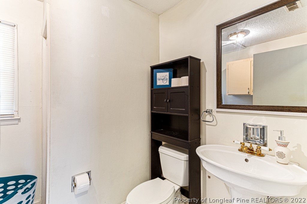 1435 Marlborough Road Fayetteville, NC 28304 - Photo 26 of 35 a bathroom with a sink toilet and mirror